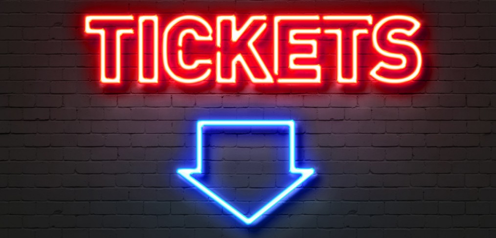 Tickets neon sign on brick wall background